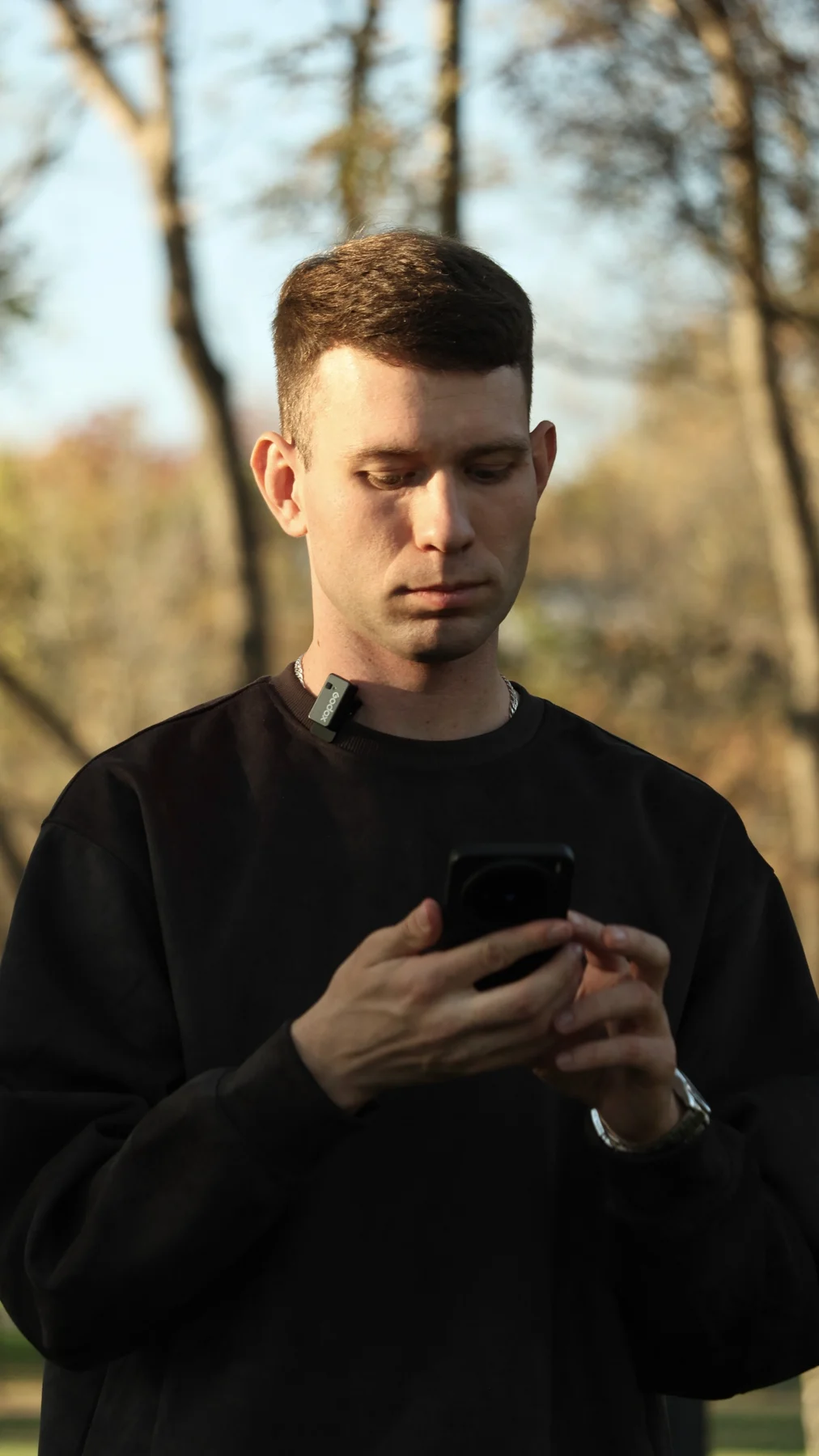 Дмитрий с телефоном в парке
